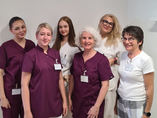 Das sechsköpfige Team der Podologie Lyss vor heller Wand